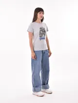 Remera negra de algodón con estampado frontal de la palabra "MERCI" en letras delineadas con colores del arcoíris.