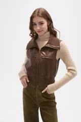 Chaleco cropped de eco-cuero color marrón, con cierre frontal, cuello solapa y bolsillos con cierre en el pecho.