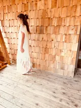 Vestido tejido color blanco con hilo metalizado, corte oversized, mangas cortas y flecos en el ruedo.