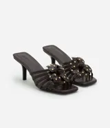 Sandalia mule color marrón con punta cuadrada, tira con flor y aplicación de strass, y tacón fino alto.