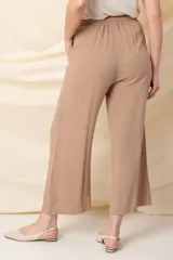Pantalón ancho color beige, de hilo, con cintura elastizada ajustable con cordón y bolsillos laterales.