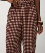 Pantalón modelo aladino de corte holgado y fluido, confeccionado en chiffon con estampado de cuadros. Presenta cintura elástica y puños ajustados en el dobladillo, ofreciendo una silueta tipo globo.