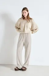 Sweater de punto fino con textura esponjosa, diseño holgado, cuello barco y mangas largas con caída relajada.