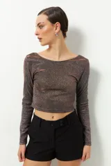 Top plateado brillante de manga larga y cuello redondo.