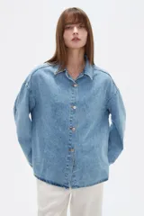 Campera de jean de corte holgado, con cuello camisero, cierre frontal con botones metálicos y mangas largas.