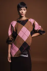 Sweater holgado con diseño de rombos en tonos marrón, negro y rosado, con detalles de lurex en las líneas divisorias. Presenta cuello redondo, mangas largas con puños acanalados y un corte relajado.