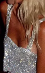 Top corto plateado con strass, breteles anchos y espalda regulable.