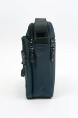 Morral de diseño compacto en color azul marino, con múltiples compartimentos con cierre, manija superior y correa ajustable para llevar al hombro. Incluye etiqueta con logo de la marca en la parte frontal.