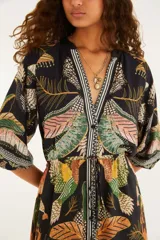 Vestido largo negro con estampado multicolor de inspiración tropical y geométrica, escote en V, mangas tres cuartos amplias y cordón ajustable en la cintura.