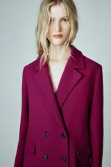Abrigo Zara de corte entallado confeccionado en mezcla de lana. Presenta cuello con solapas de muesca, hombreras, bolsillos delanteros con solapa y cierre frontal cruzado con doble botonadura. Incluye forro interior a contraste.