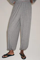 Pantalón bombacho confeccionado en mezcla de lyocell, color gris melange. Presenta tiro medio, cintura elástica con cordón de ajuste, pierna ancha y bajo abullonado con elástico.