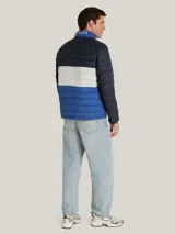 Chaqueta acolchada de diseño color block en tonos azul marino, blanco y azul brillante. Presenta cuello alto, cierre frontal con cremallera y bolsillos laterales con cierre. Incluye el logo de la marca bordado en el pecho y detalle distintivo en la manga.