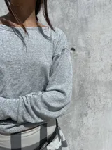 Buzo de cuello bote confeccionado en tela angorina elastizada, con diseño de hombros caídos y ajuste en la cintura.