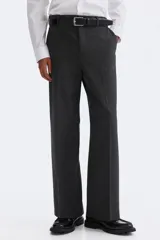 Pantalón de corte relajado en color gris oscuro, con cintura elástica, cierre de botón y cordón de ajuste oculto. Presenta raya marcada en las piernas, bolsillos laterales al bies y bolsillos traseros ribeteados con botón.