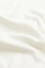 Polera blanca de punto fino, con cuello alto, mangas largas y bajo recto. Cuello, puños y bajo acanalados.