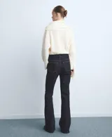 Pantalón de jean azul oscuro de corte flare, tiro medio y estilo clásico de cinco bolsillos.
