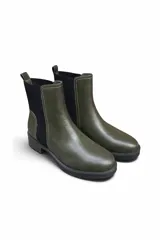 Bota tipo chelsea de cuero sintético marrón, con paneles laterales elásticos negros, costuras visibles en contraste y suela track gruesa de goma negra con tacón bajo.