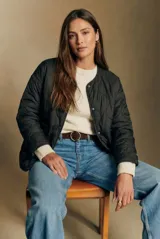 Campera reversible de diseño acolchado con cierre frontal de botones a presión, cuello redondo y mangas largas. Presenta un acabado ligero y versátil.
