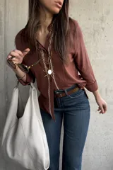 Camisa de tejido liviano y calce relajado, color marrón chocolate, con cuello mao, mangas largas y detalle de puntilla y bordado en contraste a lo largo de la botonadura frontal.