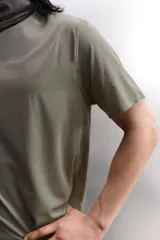 Camiseta de entrenamiento regular fit color beige, confeccionada en combinación de tejidos técnicos ligeros y elásticos con tecnología Quick Dry nivel 2. Presenta cuello redondo, manga corta, acabados con costuras planas y termofijadas, y detalle de logo estampado en el bajo.