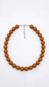 Collar corto de cuentas esféricas grandes color marrón con acabado brillante y cierre metálico plateado con cadena de alargue.