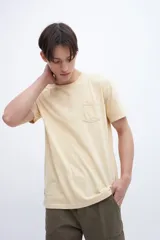 Remera color beige claro de manga corta con bolsillo en el pecho.