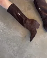 Bota de caña media color marrón chocolate, de gamuza, con punta fina y taco cónico.