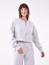 Campera tipo hoodie cropped de color azul marino, con cierre frontal completo, capucha y mangas largas con puños elásticos.