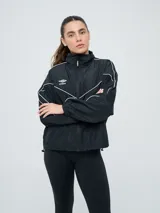 Campera cortaventos Umbro de diseño colorblock en tonos celeste, beige y azul marino, con cuello alto, cierre frontal y bolsillos laterales.
