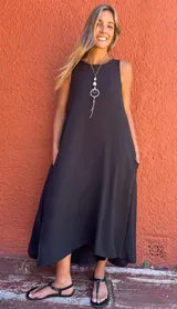 Vestido largo negro de seda opaca, con bolsillos laterales, corte en A y diseño con cortes laterales en la espalda.