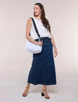 Cartera bandolera de lona blanca con silueta de medialuna, cierre superior negro y correa regulable en contraste.