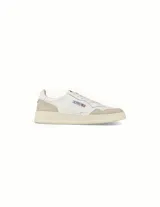 Championes de estilo vintage inspirados en los años 80, confeccionados en cuero blanco con detalles en gamuza beige. Presentan punta perforada, cordones planos de algodón, cuello acolchado y suela de goma con logo en relieve.