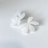Par de aros con forma de flor de cinco pétalos color blanco.