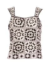 Polera sin mangas tejida en crochet con diseño de motivos cuadrados en tonos blanco, negro y gris. Presenta cuello cuadrado y breteles anchos.
