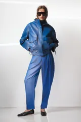 Pantalón de tiro alto con diseño de volumen, pinzas en el delantero, bolsillos laterales ocultos y bolsillos traseros de vivo. Cierre frontal con cremallera y ganchos metálicos.