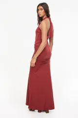 Vestido largo color verde oscuro, de corte entallado y silueta fluida, con escote halter pronunciado y detalle fruncido en la cintura.