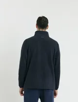 Campera de micropolar color verde oscuro, con cuello alto, cierre frontal completo, bolsillos laterales y un bolsillo con cierre en el pecho.
