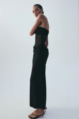 Vestido midi negro de escote palabra de honor, con diseño combinado de paneles de distintos acabados y detalle drapeado en la zona frontal y de la cintura. Cuenta con cierre lateral de cremallera oculta.