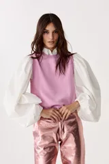 Top tejido de punto color rosa con lúrex, sin mangas y cuello a la base.