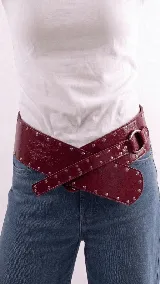 Faja ancha de cuero color bordó con diseño cruzado, decorada con tachas metálicas plateadas y hebilla de argolla.