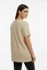 Remera de algodón manga corta con cuello redondo y corte al cuerpo. Presenta un estampado central con diseño artístico y detalles de studs aplicados.