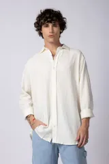 Camisa de manga larga confeccionada en lino, de corte holgado y diseño minimalista con cuello clásico y cierre frontal de botones.