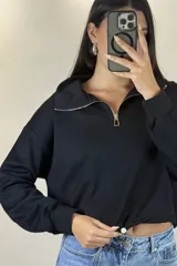 Buzo deportivo color blanco con cuello polo y cierre frontal parcial. Presenta mangas largas con puños elásticos y ruedo ajustable con cordón elástico.