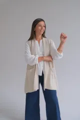 Chaleco largo abierto de tejido de punto color crudo, con bolsillos frontales aplicados y diseño sin mangas.