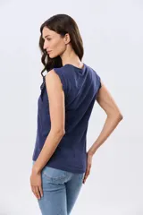 Musculosa de algodón color azul con detalles de broderie calado en los hombros, de cuello redondo y corte clásico.