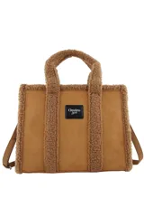 Cartera tipo tote de Las Oreiro, confeccionada en gamuza sintética color beige con detalles de corderito en los bordes y manijas. Incluye un parche frontal con el logo de la marca y correa ajustable extraíble.