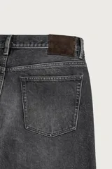 Jeans straight fit de corte recto y tiro medio, confeccionados en denim de algodón rígido con efecto lavado en color negro, de la colección especial Aaron Levine x Zara. Presentan diseño clásico de cinco bolsillos y cierre frontal con botonadura.