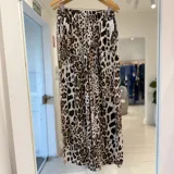 Pantalón de corte ancho y fluido, con cintura elástica fruncida y estampado animal print en tonos negro, marrón y crudo.