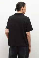 Camisa de manga corta color ciruela, con cuello polo y botones frontales.