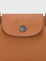 Cartera de hombro compacta de cuero en color tostado, de formato alargado y horizontal, con asas finas y cierre superior con solapa y broche a presión.